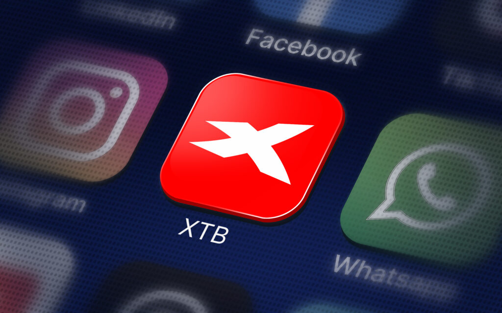 Red rounded app icon with a white X, labeled XTB, on a phone screen